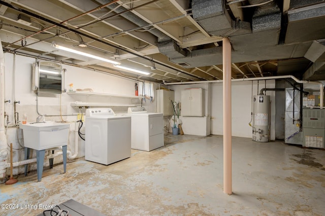 basement with heating unit, washer and clothes dryer, sink, and water heater