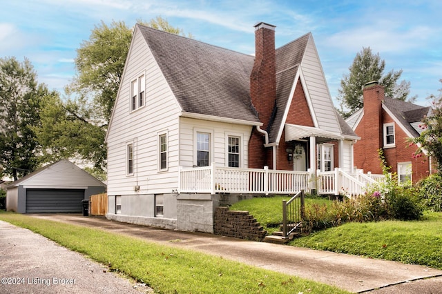 view of front of home with a garage, an outdoor structure, and a front yard