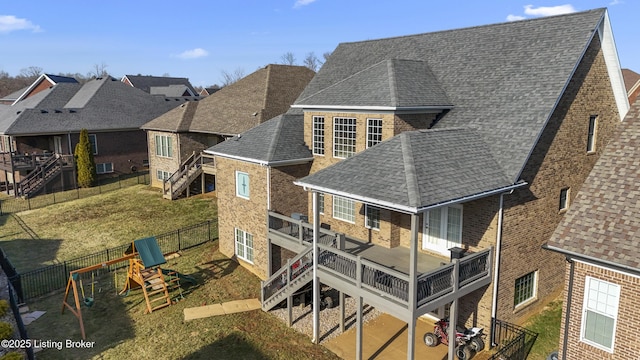 rear view of property with a playground and a yard