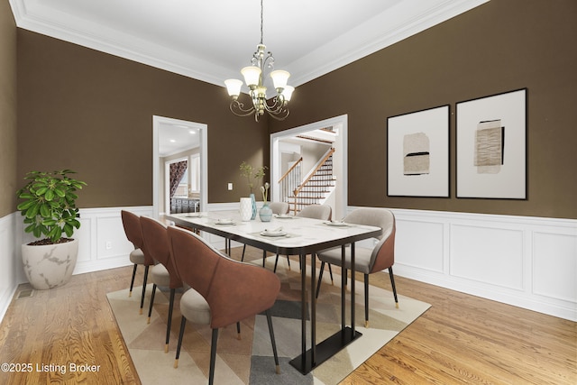 dining room featuring crown molding, light hardwood / wood-style flooring, and a notable chandelier