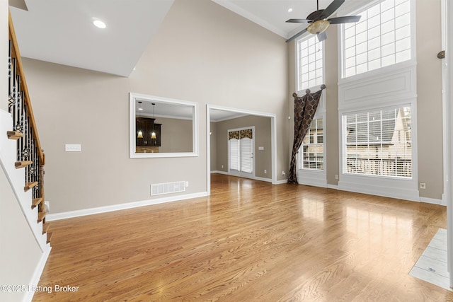 unfurnished living room with ceiling fan, high vaulted ceiling, light hardwood / wood-style floors, and a wealth of natural light