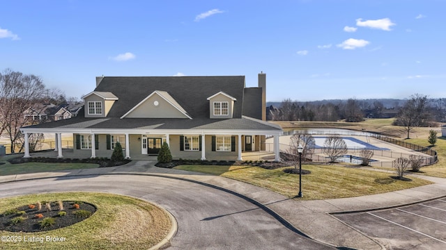 view of front of home with covered porch and a front lawn