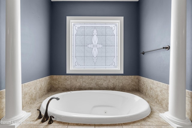 bathroom with a relaxing tiled tub and decorative columns