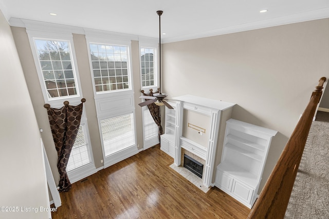 living room featuring dark hardwood / wood-style flooring, a fireplace, ornamental molding, and ceiling fan