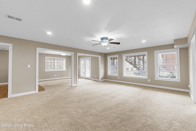 unfurnished living room featuring ceiling fan and light colored carpet