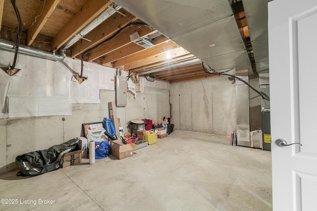 basement featuring heating unit and electric panel