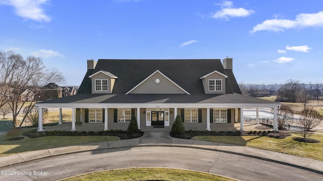 view of front of house with covered porch and a front lawn