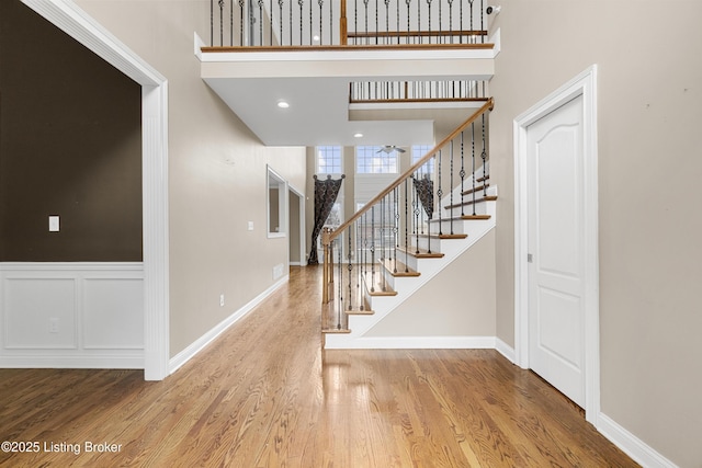 entryway featuring hardwood / wood-style flooring and a towering ceiling