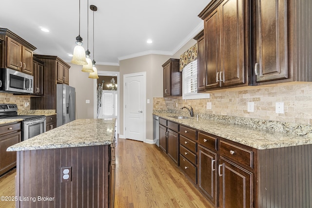 kitchen featuring appliances with stainless steel finishes, decorative light fixtures, sink, and dark brown cabinets