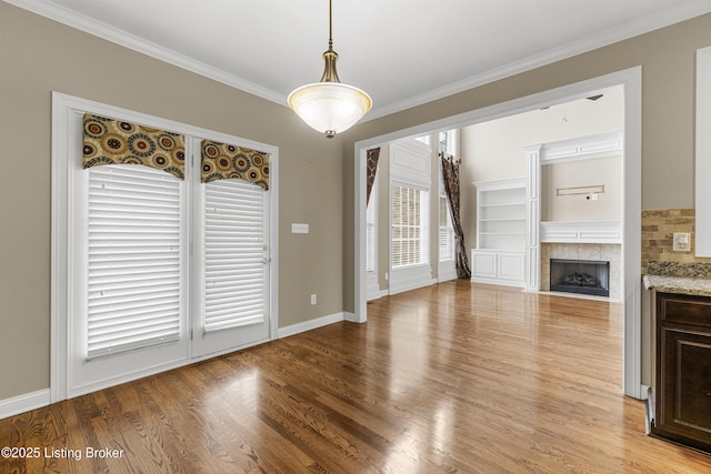 unfurnished living room featuring crown molding, a fireplace, and light hardwood / wood-style flooring