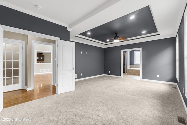 interior space featuring a raised ceiling, ornamental molding, and ceiling fan