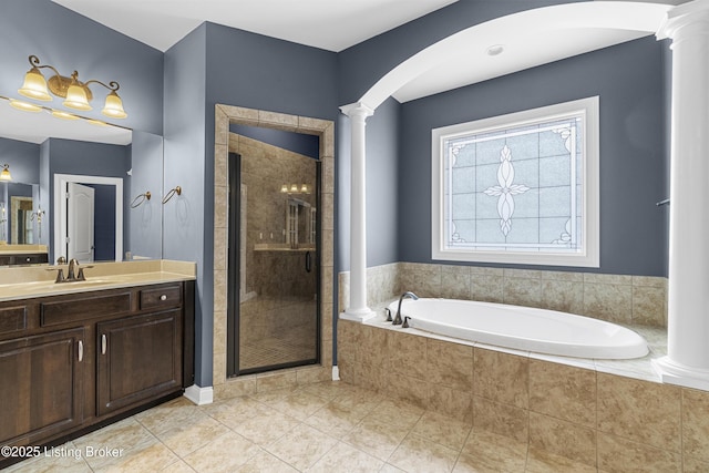 bathroom featuring tile patterned floors, vanity, shower with separate bathtub, and ornate columns