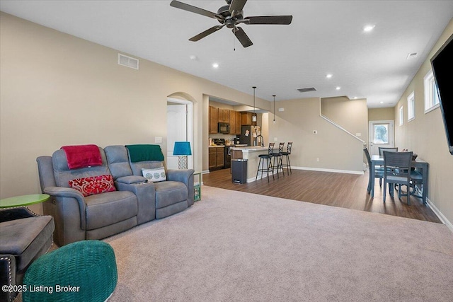 carpeted living room featuring sink and ceiling fan