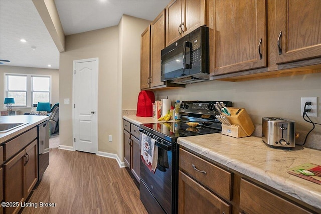 kitchen featuring dark hardwood / wood-style floors, sink, and black appliances