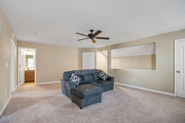 carpeted living room with ceiling fan and a textured ceiling