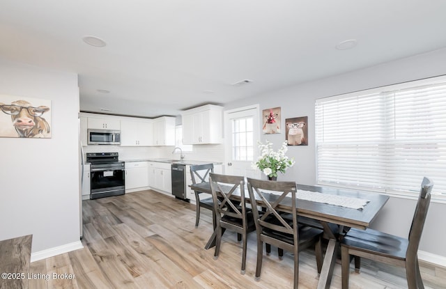 dining room with sink and light hardwood / wood-style flooring