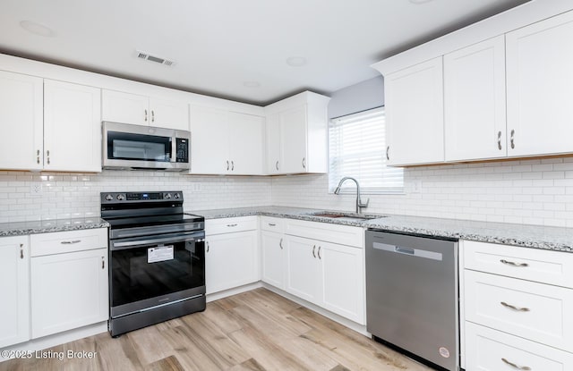 kitchen with white cabinetry, sink, and stainless steel appliances