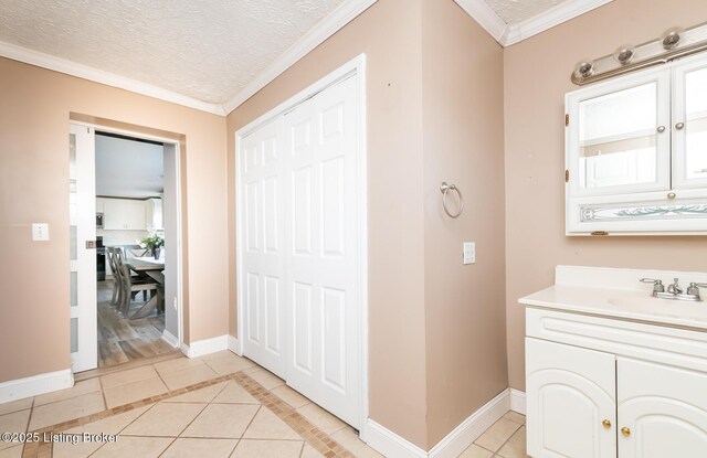 bathroom featuring vanity, ornamental molding, tile patterned floors, and a textured ceiling