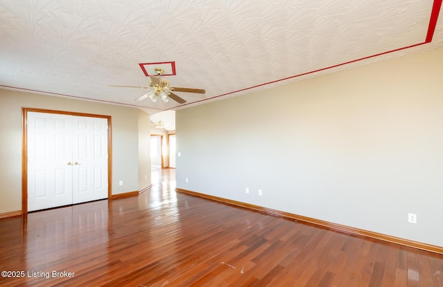 unfurnished bedroom featuring hardwood / wood-style flooring, ceiling fan, and a textured ceiling