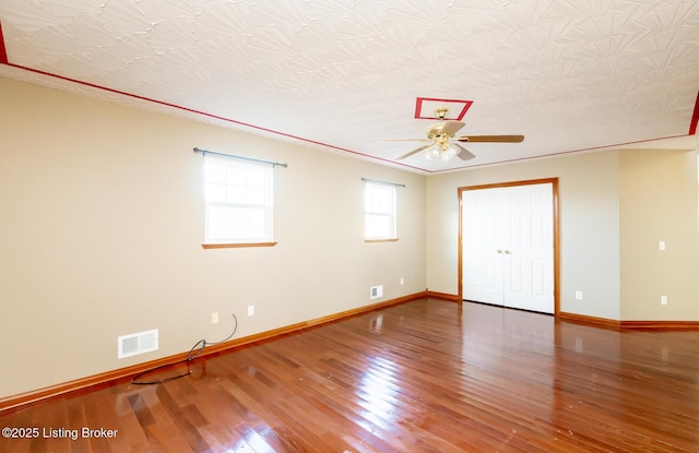 empty room with hardwood / wood-style flooring, ceiling fan, and a textured ceiling