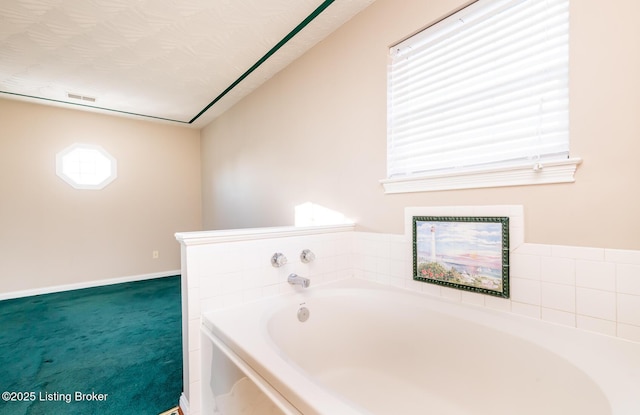 bathroom with a tub and a textured ceiling