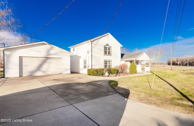 view of front of house with a garage, an outdoor structure, and a front yard