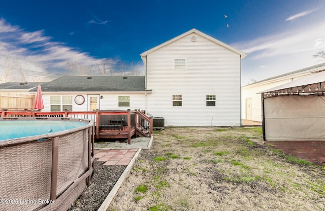 back of house with a pool side deck and central AC unit