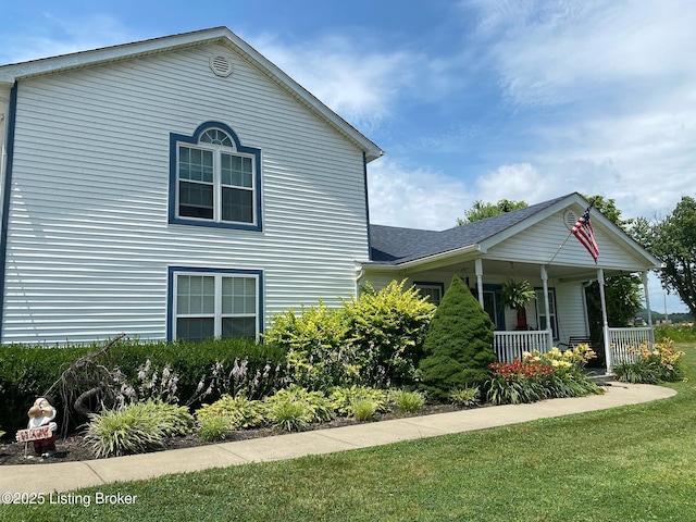 view of property exterior featuring a yard and covered porch