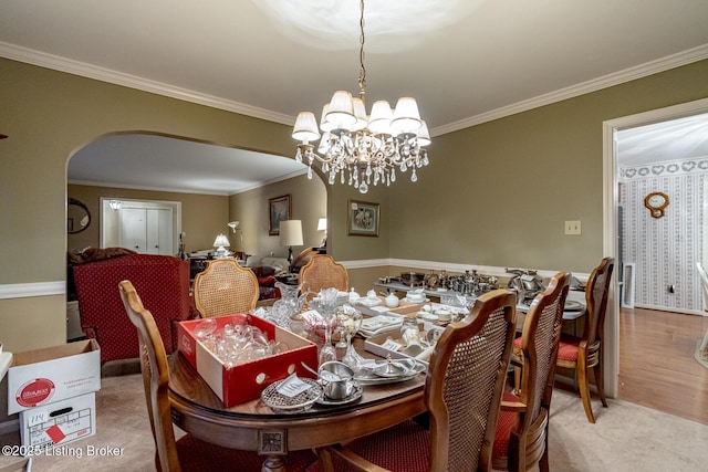 dining area featuring a notable chandelier, crown molding, and light wood-type flooring