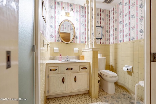 bathroom featuring vanity, tile walls, tile patterned floors, and toilet