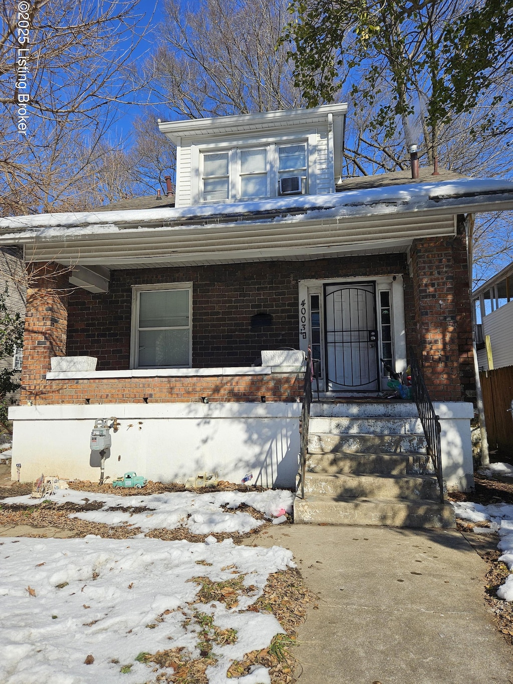 snow covered property entrance featuring covered porch