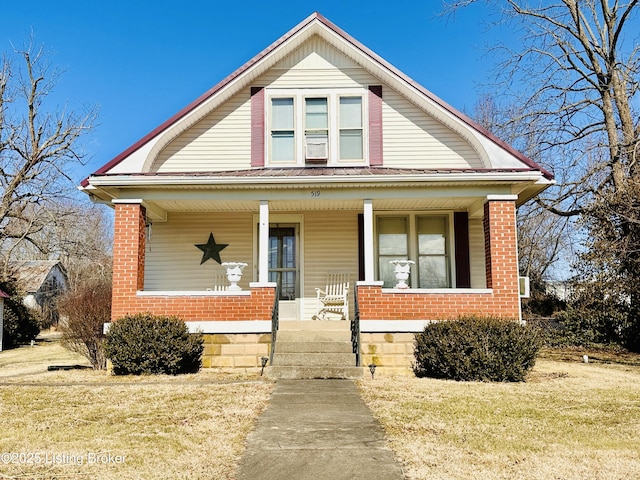 bungalow featuring covered porch and a front yard