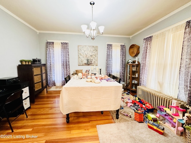 bedroom with radiator heating unit, ornamental molding, hardwood / wood-style floors, and an inviting chandelier