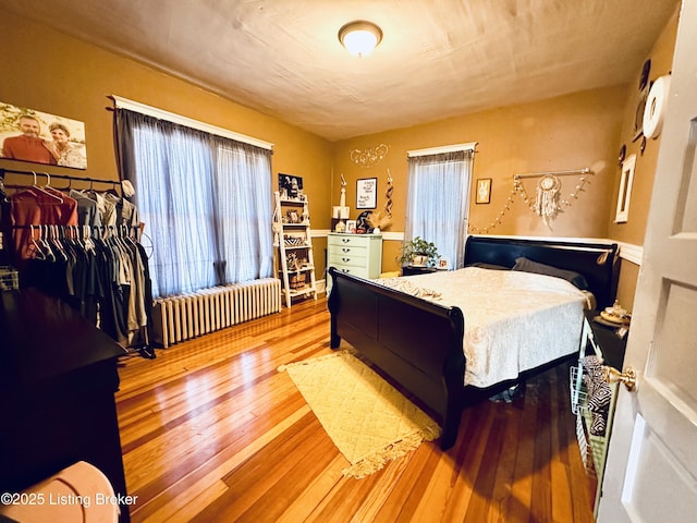 bedroom featuring hardwood / wood-style flooring and radiator heating unit