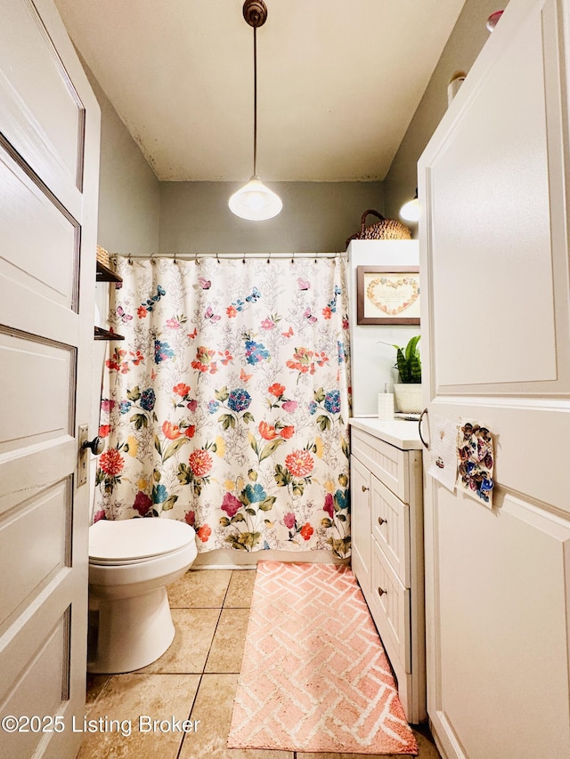 bathroom featuring tile patterned flooring, toilet, and walk in shower