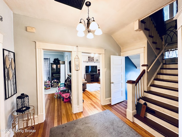 interior space with vaulted ceiling, a chandelier, and hardwood / wood-style floors