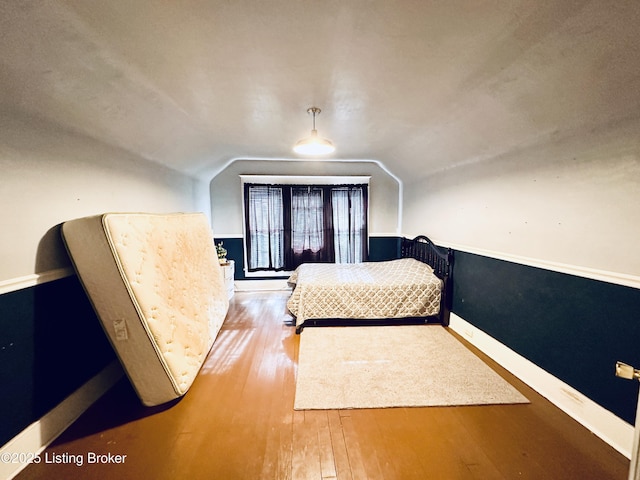 bedroom with hardwood / wood-style flooring and vaulted ceiling