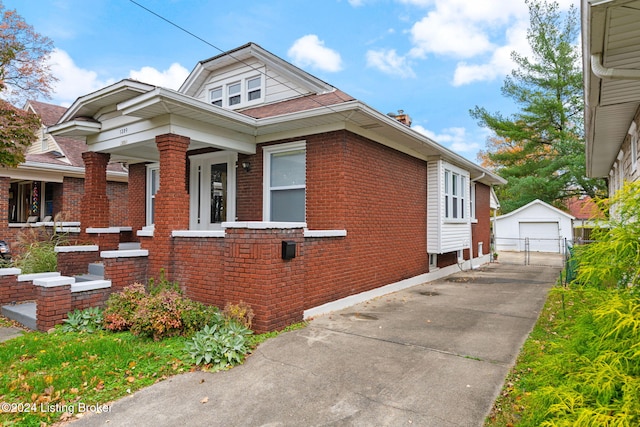 view of front of house featuring a garage, an outdoor structure, and covered porch