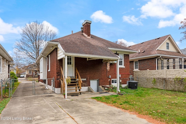 rear view of house featuring a yard and central AC unit