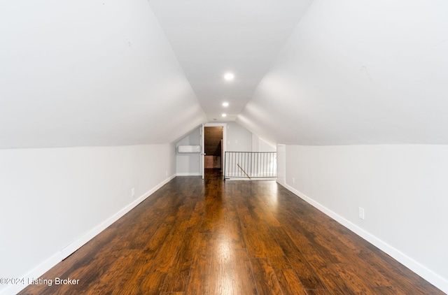 additional living space featuring lofted ceiling and dark hardwood / wood-style flooring