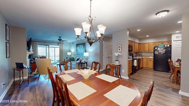 dining area featuring dark hardwood / wood-style flooring and ceiling fan with notable chandelier