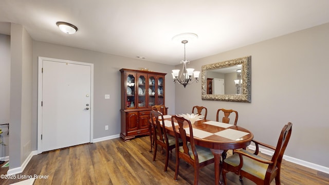 dining area featuring dark hardwood / wood-style flooring and a notable chandelier