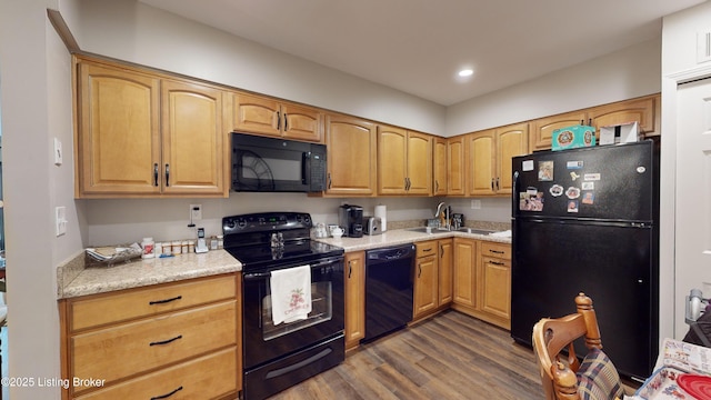 kitchen featuring light stone counters, dark hardwood / wood-style flooring, sink, and black appliances