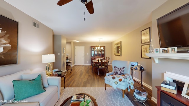 living room with wood-type flooring and ceiling fan with notable chandelier