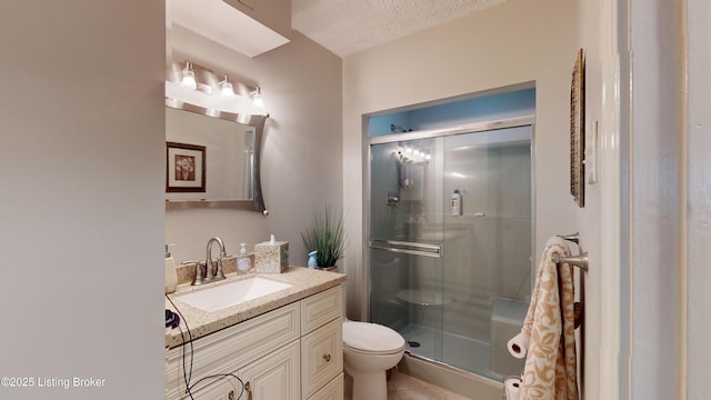 bathroom featuring vanity, a textured ceiling, a shower with door, and toilet