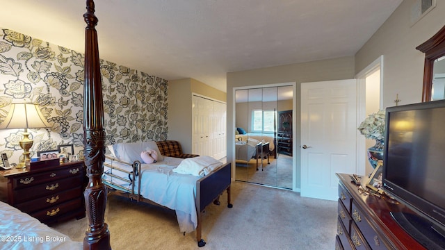 bedroom featuring multiple closets and light colored carpet