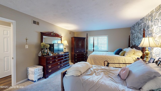 bedroom featuring light colored carpet and a textured ceiling