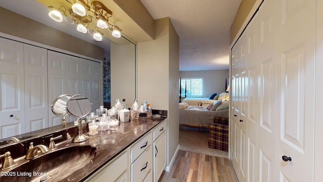 bathroom featuring vanity, hardwood / wood-style floors, and an inviting chandelier