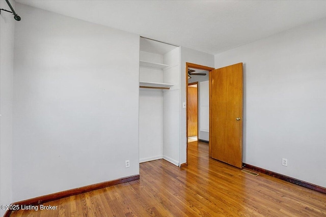 unfurnished bedroom with hardwood / wood-style flooring and a closet