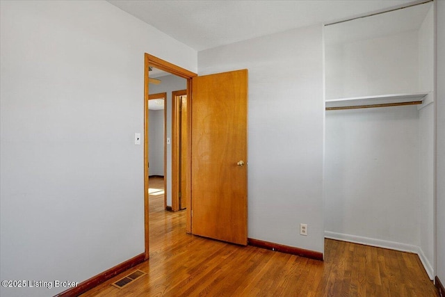 unfurnished bedroom featuring hardwood / wood-style floors and a closet